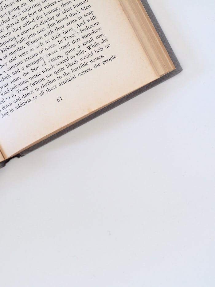 Close-up of a book open to page 61 with text visible against a white background.